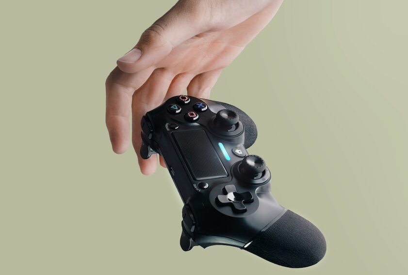 person holding Sony DualShock 4 wireless controller