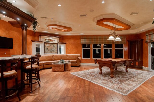 billiard table in center of brown painted room